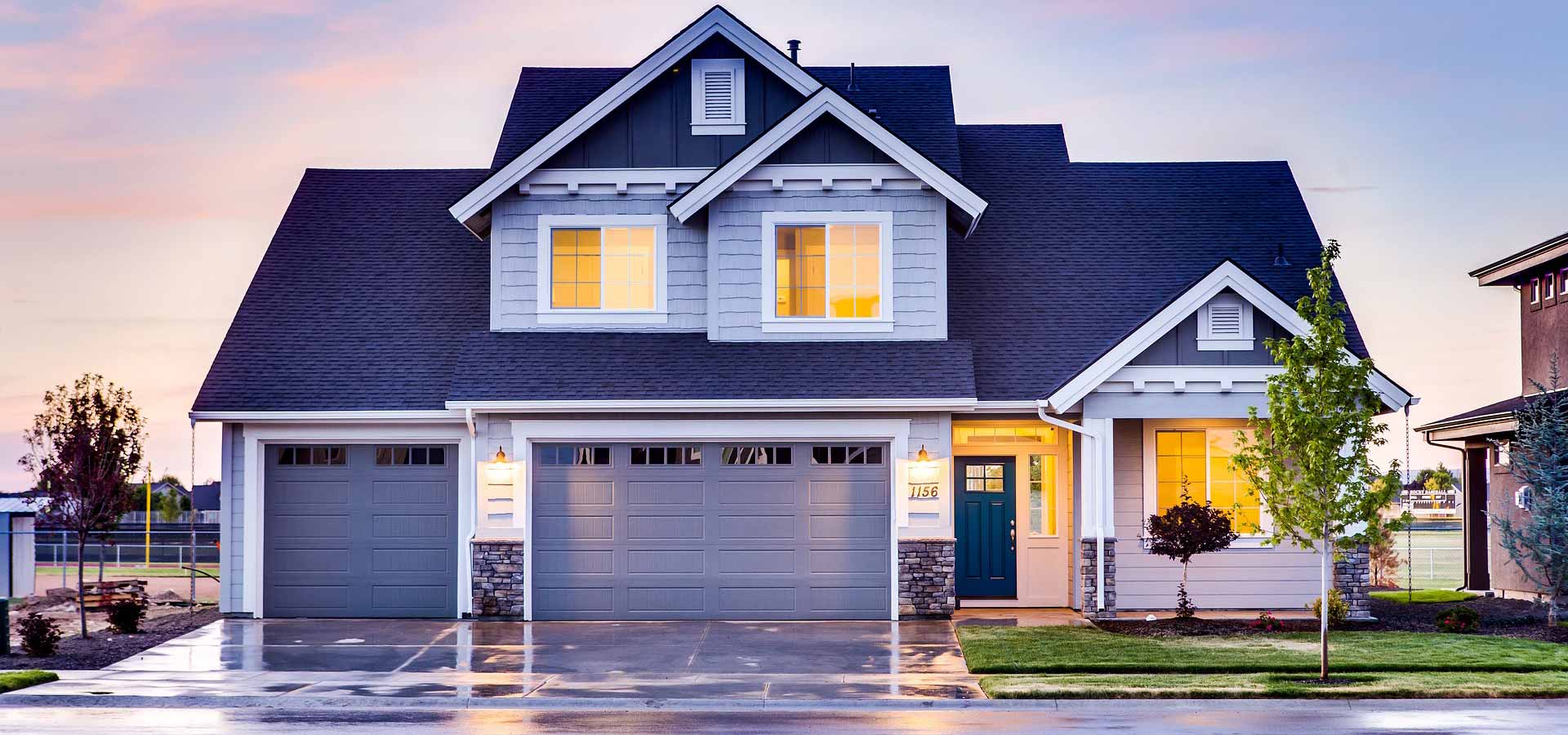 blue and white two story home with inside lights on