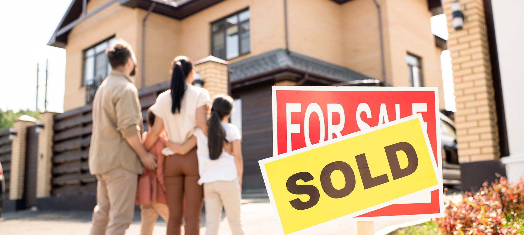 young-couple-and-child-in-front-of-new-house