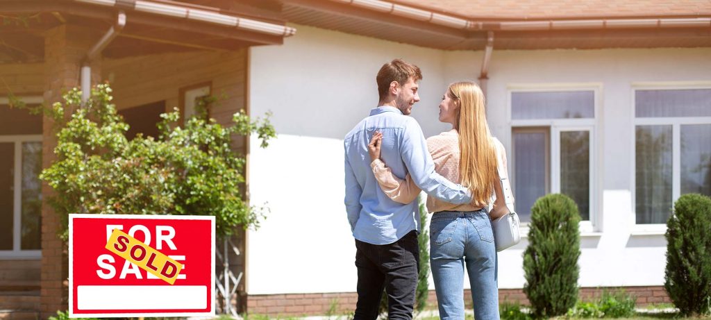 newlywed-couple-standing-in-front-yard-of-their-new-housex2000